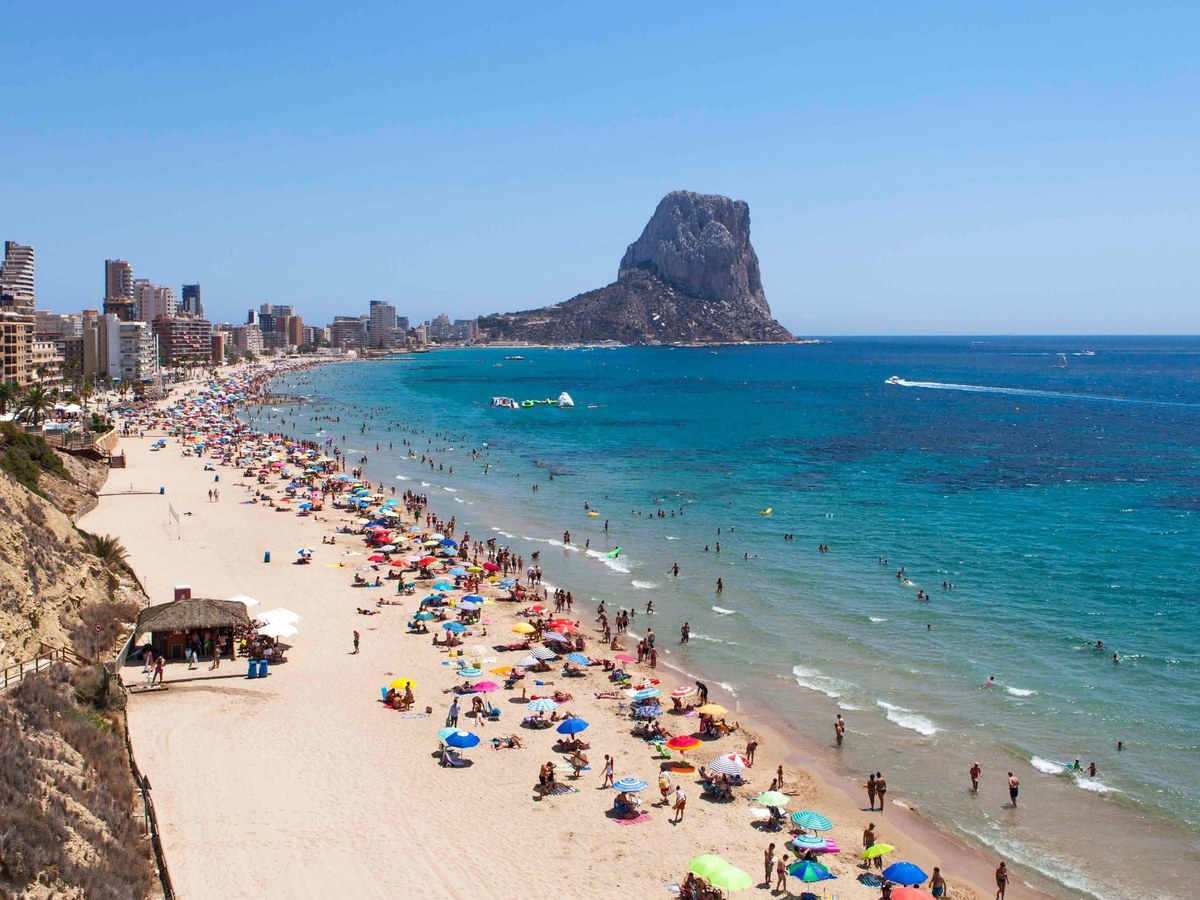 Calpe's beach on a summer day, with the Peñón de Ifach beyond it