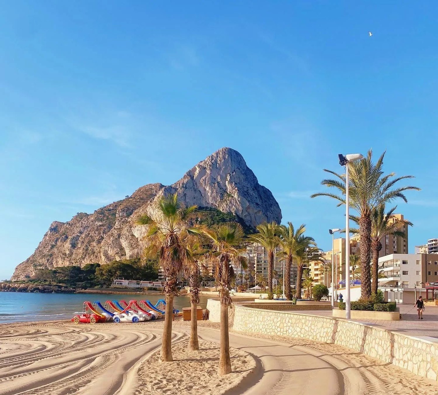 La playa y el paseo de Calpe una mañana tranquila, con el Peñón de Ifach al fondo